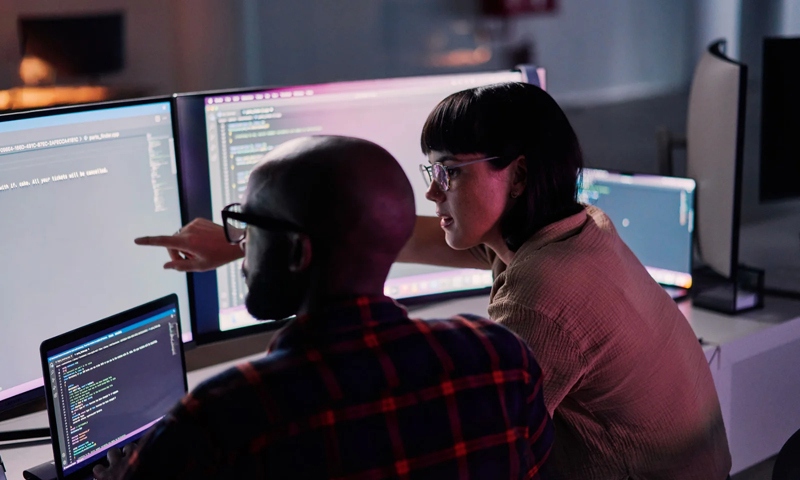 Collaborative Coding Session with Wynxx GenAI for Software Development Two developers working together on multiple monitors displaying code and software development tools powered by Wynxx GenAI